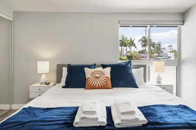 a bedroom with a large bed with blue pillows at Galactic Getaway Close to Disney with Pool and Games in Anaheim