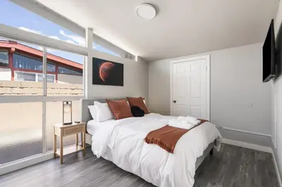 a bedroom with a bed and a large window at Galactic Getaway Close to Disney with Pool and Games in Anaheim