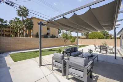 a patio with a canopy and chairs and a table at Galactic Getaway Close to Disney with Pool and Games in Anaheim