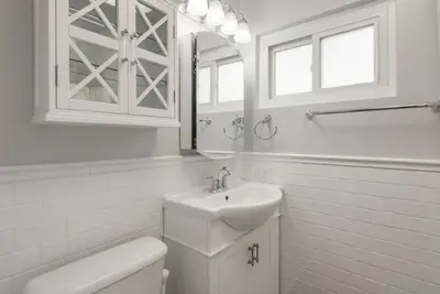 a bathroom with a sink and a toilet and a mirror at Refreshing Escape- Hot Tub- Games- Sleeps 10 in Long Beach
