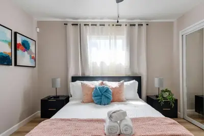 a bedroom with a large bed with a blue pillow at Aqua Oasis - Games - Close to DT - Sleeps 10 in Montebello