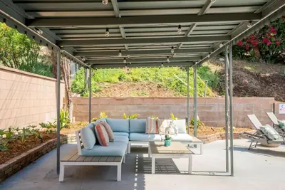 a pergola with blue couches and tables on a patio at Aqua Oasis - Games - Close to DT - Sleeps 10 in Montebello