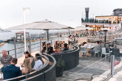a group of people sitting at a restaurant at Trendy Getaway - Hot Tub - Putt Putt - Games in Long Beach