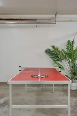 a red ping pong table in a room with a plant at Trendy Getaway - Hot Tub - Putt Putt - Games in Long Beach