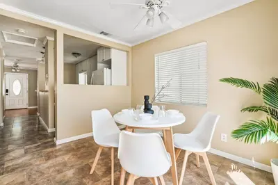 a dining room with a white table and white chairs at Serene Yard Porch at Signal Hill - Close to the Beach in Signal Hill