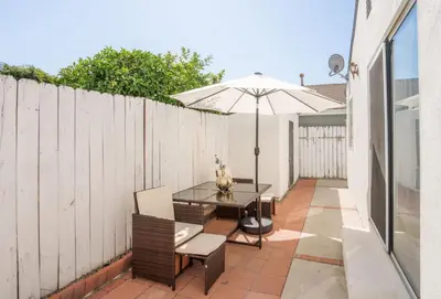 a patio with a table and an umbrella at Serene Yard Porch at Signal Hill - Close to the Beach in Signal Hill
