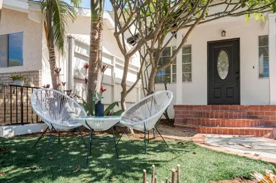 two chairs sitting in the yard in front of a house at Serene Yard Porch at Signal Hill - Close to the Beach in Signal Hill