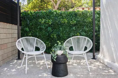two white chairs and a pot with a plant at Iconic LACasita -FoodieBobaliciousCity- Mins2DTLA in Alhambra
