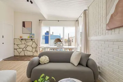 a living room with a couch and a brick wall at Gorgeous Beachside Bliss Ocean View Walk2Strand in Manhattan Beach
