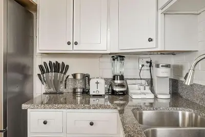 a kitchen with white cabinets and a counter top at Gorgeous Beachside Bliss Ocean View Walk2Strand in Manhattan Beach