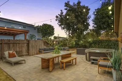 a patio with a table and chairs and a fence at Surfers Dreams - 5min Drive to Beach with PoolTable in Long Beach