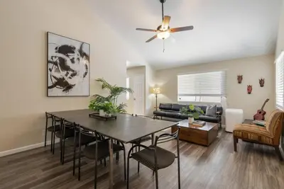 a living room with a dining room table and a couch at Surfers Dreams - 5min Drive to Beach with PoolTable in Long Beach
