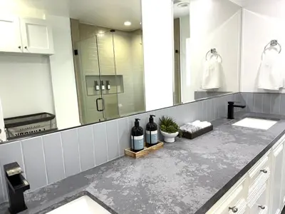 a bathroom with two sinks and two bottles of wine at Woodland Hills 1 Bedroom Getaway in Woodland Hills