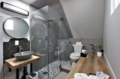 a bathroom with a toilet and a glass shower at The Train Getaway Big Bear Lake in Big Bear Lake