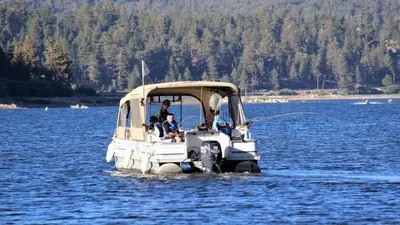 a man and a child in a small boat in the water at The Train Getaway Big Bear Lake in Big Bear Lake