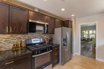 a kitchen with wooden cabinets and a stainless steel refrigerator at Historic Heart of Hollywood *Newly Renovated * in Los Angeles