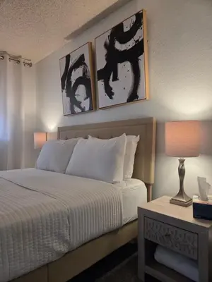 a bedroom with a bed with three pictures on the wall at Minimalist Lake House in Helendale