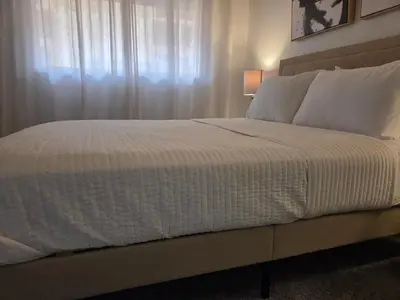 a bedroom with a large bed with a window at Minimalist Lake House in Helendale