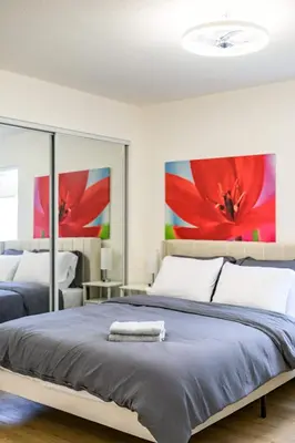 a bedroom with two beds with red flowers on the wall at Luxe Spacious Home Near Parks Fully Equipped in Riverside