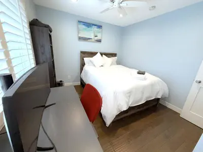 a bedroom with a bed with a table and a chair at Mountain View • Pool House in Chino Hills