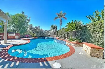 a swimming pool in a yard with a palm tree at Mountain View • Pool House in Chino Hills