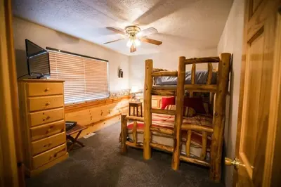 a bedroom with a bunk bed and a ceiling fan at Luxury w Spa Foosball Near Summit - DeCarlo House in Big Bear Lake