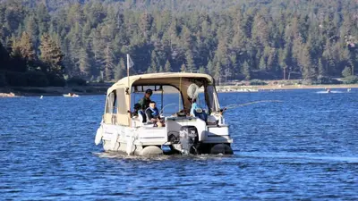 a man and a child in a small boat in the water at Luxury w Spa Foosball Near Summit - DeCarlo House in Big Bear Lake