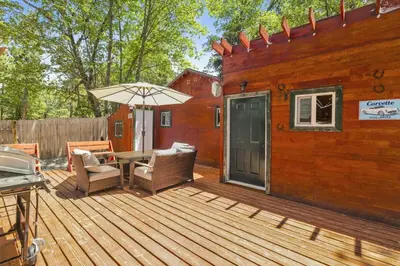 a wooden deck with a table and an umbrella at Lily's Bear Cabin -Adorable Downtown Retreat Cottage in Big Bear Lake