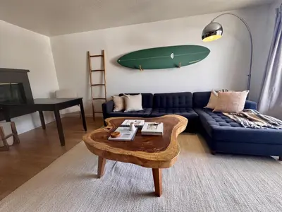 a living room with a blue couch and a surfboard on the wall at Santa Monica 2BR Condo Views and Prime Location in Los Angeles