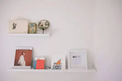a white shelf with books a clock and other items at Private and Quiet Los Feliz Guest Suite with VIEWS in Los Angeles