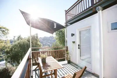 a patio with a table and an umbrella on a balcony at Private and Quiet Los Feliz Guest Suite with VIEWS in Los Angeles