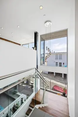 a staircase in a house with a large window at The Blue Wave - 3 blocks from Manhattan Beach Pier in Manhattan Beach