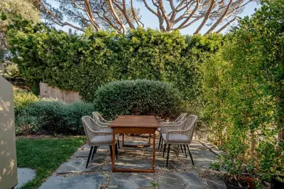 a wooden table with four chairs in a garden at Private Malibu Escape - Walk to Secluded Beach in Malibu