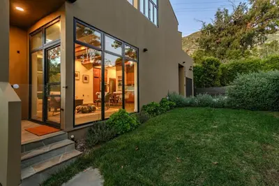 a house with large glass windows and a yard at Private Malibu Escape - Walk to Secluded Beach in Malibu