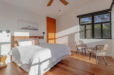 a bedroom with a bed and a chair and a window at Private Malibu Escape - Walk to Secluded Beach in Malibu
