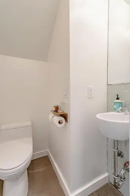 a white bathroom with a toilet and a sink at Private Malibu Escape - Walk to Secluded Beach in Malibu