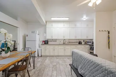 a kitchen with white cabinets and a table and a couch at Westwood UCLA 2BR, 1BA Cozy Condo w Amenities in Los Angeles