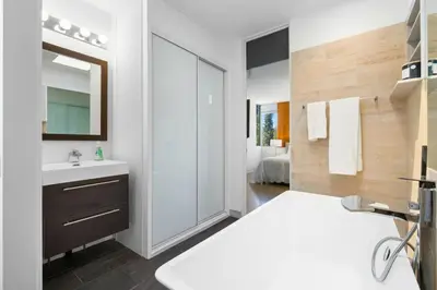 a white bathroom with a sink and a mirror at Hilltop Designer Midcentury Modern 4BR Pool HotTub in Los Angeles