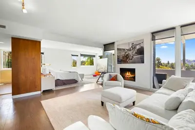 a living room with white furniture and a bedroom at Hilltop Designer Midcentury Modern 4BR Pool HotTub in Los Angeles