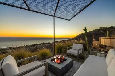 a patio with a fire pit and a view of the ocean at Luxe Malibu Retreat - Ocean Views, Hot Tub and Gym in Malibu