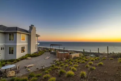 a house with a view of the ocean at sunset at Luxe Malibu Retreat - Ocean Views, Hot Tub and Gym in Malibu