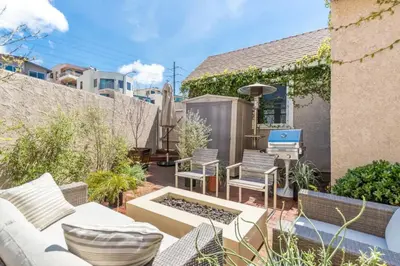 a patio with a couch and a table and chairs at Chic Beach Bungalow 3 Blocks from the Sand in Manhattan Beach