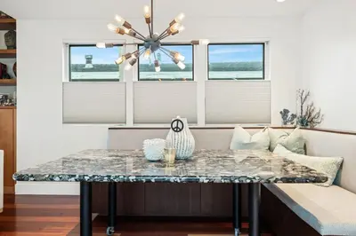 a table in a living room with a chandelier at Lux by Manhattan Beach Pier and Panoramic Ocean View in Manhattan Beach