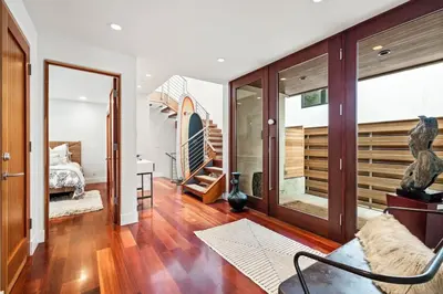 a living room with a staircase and a bedroom at Lux by Manhattan Beach Pier and Panoramic Ocean View in Manhattan Beach