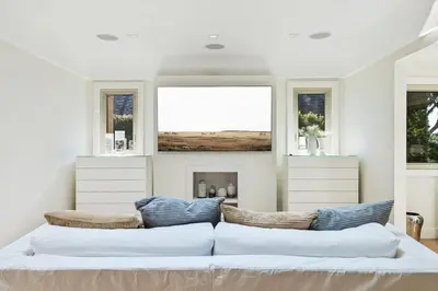 a living room with a couch and two windows at Private Designer Home in West Hollywood in Los Angeles