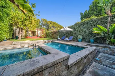 a swimming pool in a backyard with an umbrella at Atwater Oasis with Pool and HotTub very Walkable Area in Glendale