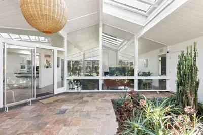 a conservatory with white walls and windows and a ceiling at Eichler Mid-Century Perfect WFH, Relax and Entertain in Orange
