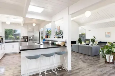 a kitchen and living room with white cabinets and blue stools at Eichler Mid-Century Perfect WFH, Relax and Entertain in Orange