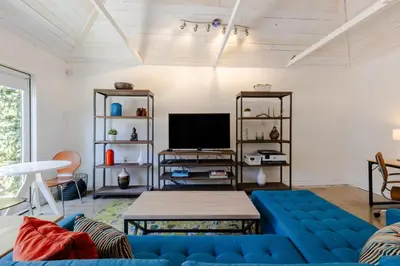 a living room with a blue couch and a tv at Heart of Venice Designer Home Near Abbot Kinney in Los Angeles