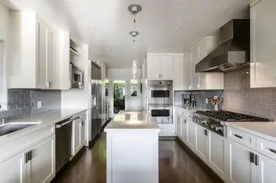 a large white kitchen with white cabinets and appliances at Hollywood Dell Oasis, Canyon VIEWS, Fire Pit and BBQ in Los Angeles
